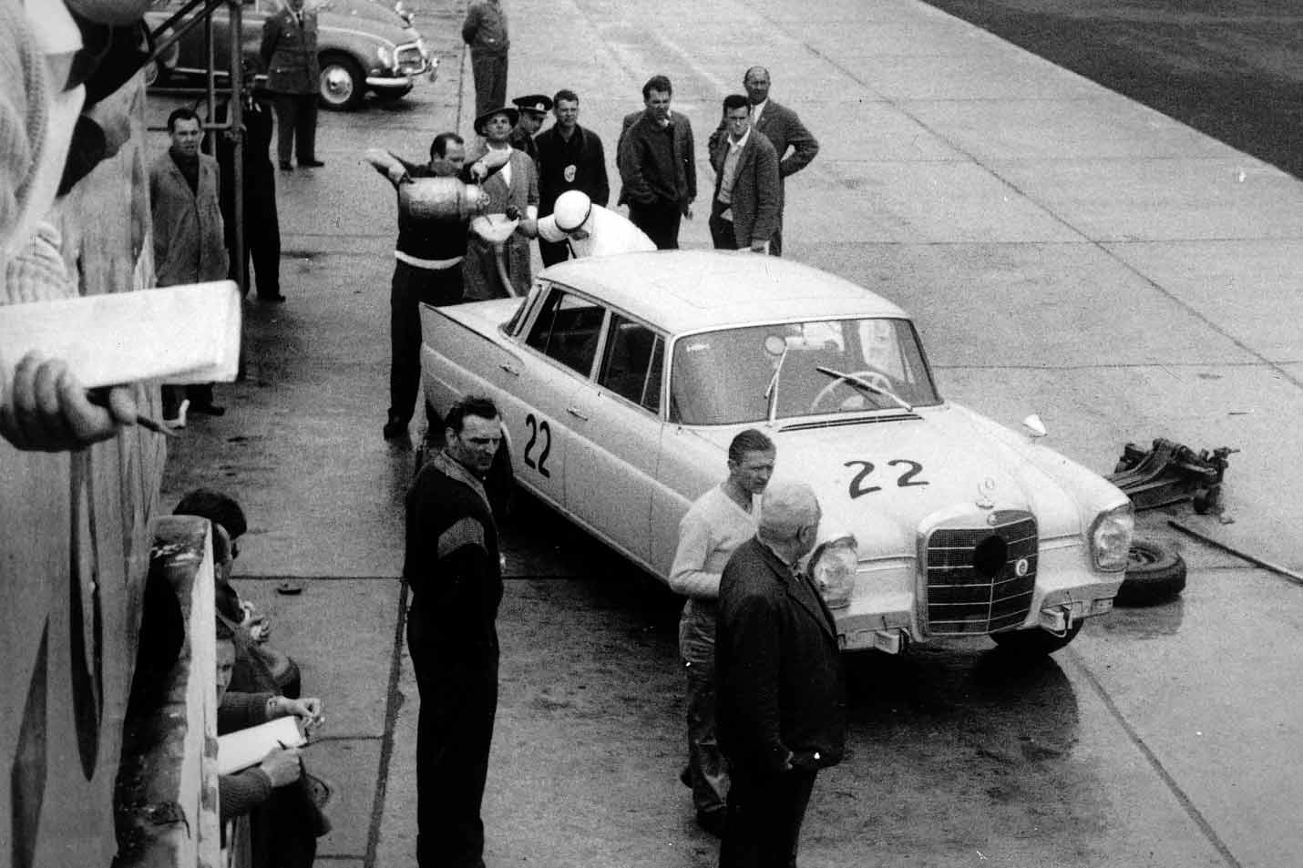 Der Fahrer Rudi Golderer mit seinem Mercedes-Benz Typ 220 SE beim Tanken an den Boxen.